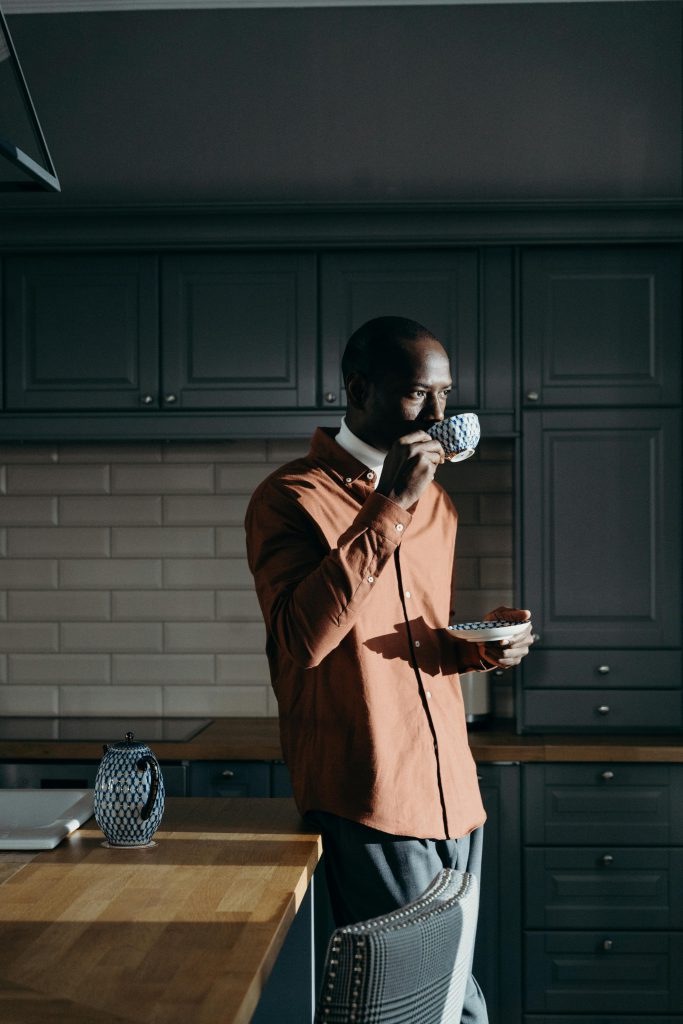pexels photo 6269879 6269879 Adult black man drinking tea indoors in a stylish kitchen with moody lighting.